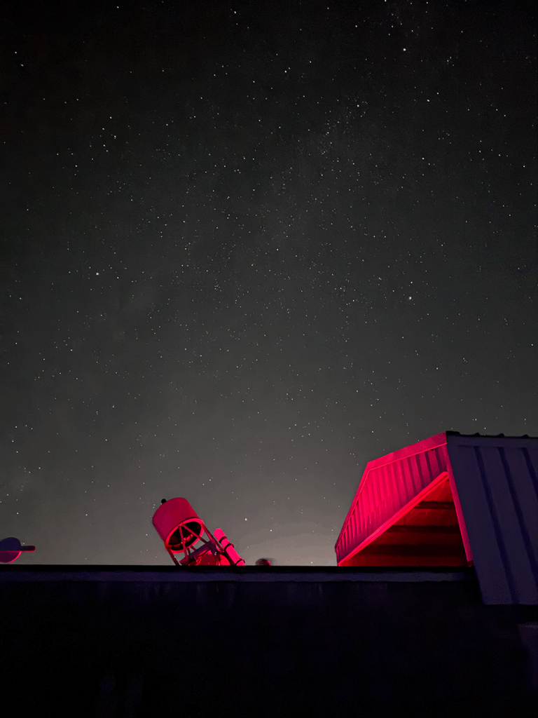 The OCA observatory with the roof open showing the Kuhn Telescope bathed in red light